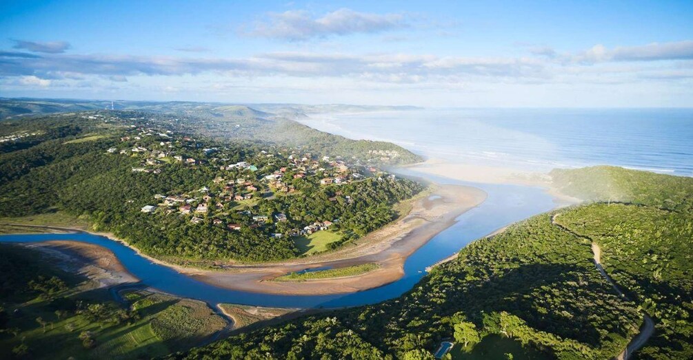 A coastal landscape with a river, a beach, and a residential area. 2