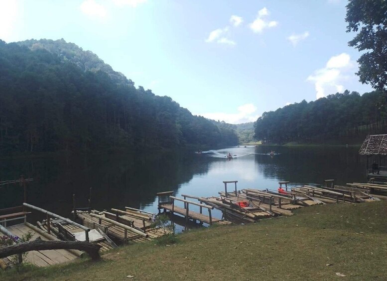 A calm river with boats, a dock, and forested banks. 5