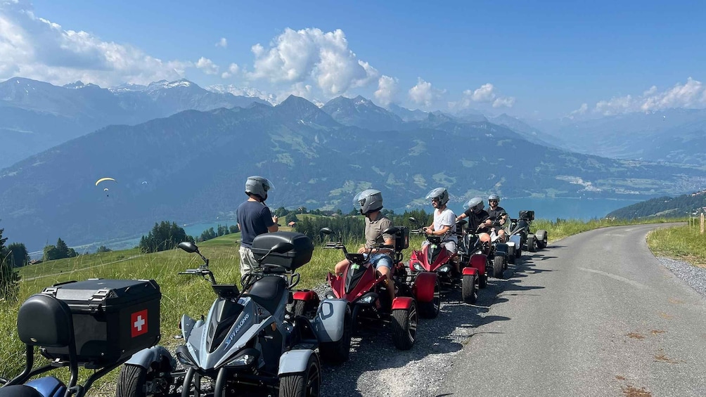 A group of motorcyclists on a road with a mountainous backdrop. 2