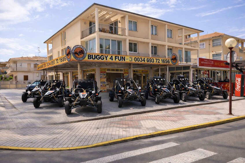 A building with a sign reading 'BUGGY 4 FUN' and several go-karts parked in front. 3