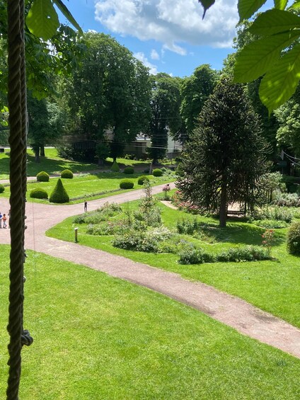A well-maintained garden with manicured lawns, a winding path, and various trees and shrubs. 4