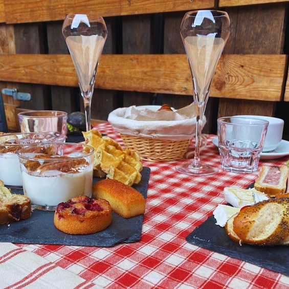 A picnic setup with food and drinks on a checkered tablecloth. 1