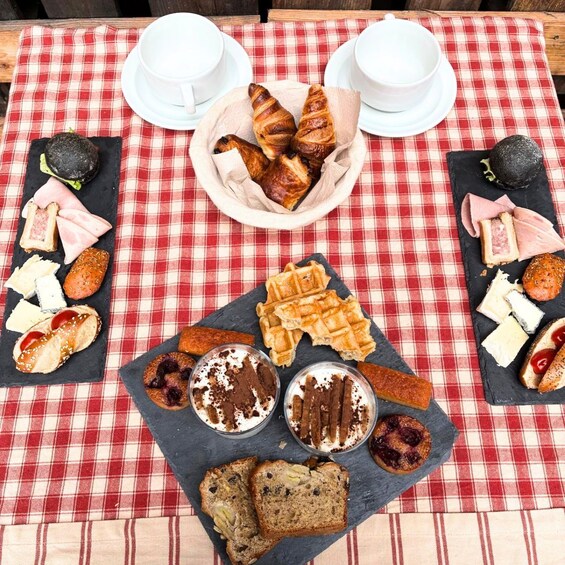 A picnic setup with various foods and drinks on a red and white checkered tablecloth. 3