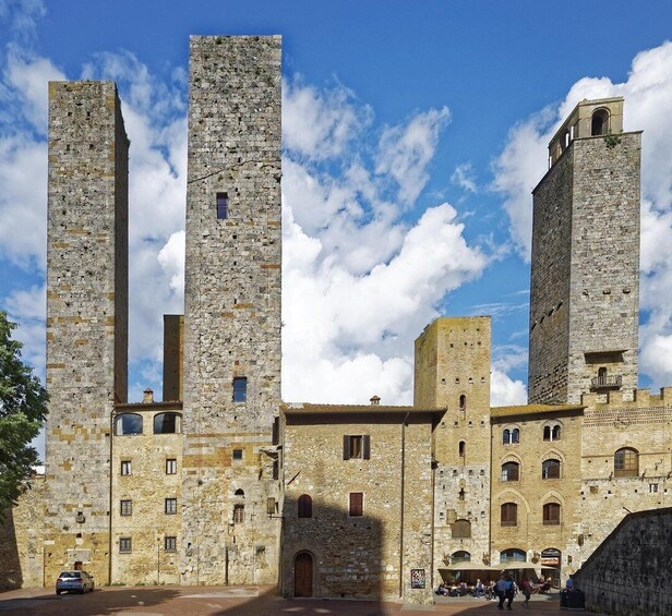A historic stone building with tall towers and a courtyard. 3