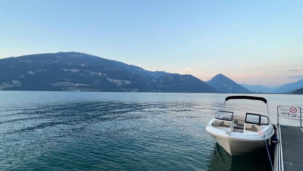 A boat docked at a pier with a mountainous landscape in the background. 5