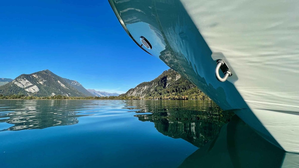 A boat's bow reflecting a mountainous landscape and calm lake. 1