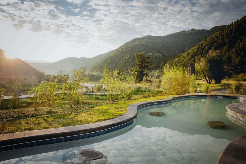 A swimming pool surrounded by a lush landscape with mountains in the background. 1