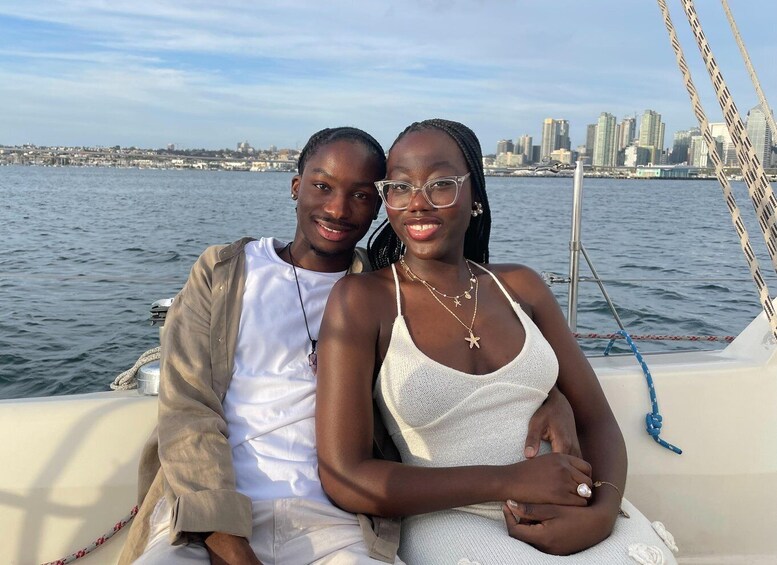 Two people on a boat with a city skyline in the background. 4