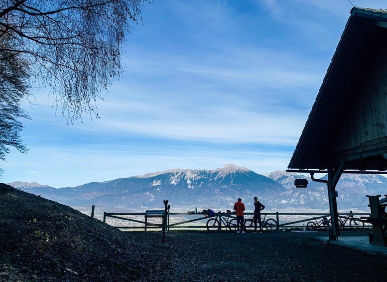 A mountain landscape with a clear sky, a wooden fence, and bicycles. 2