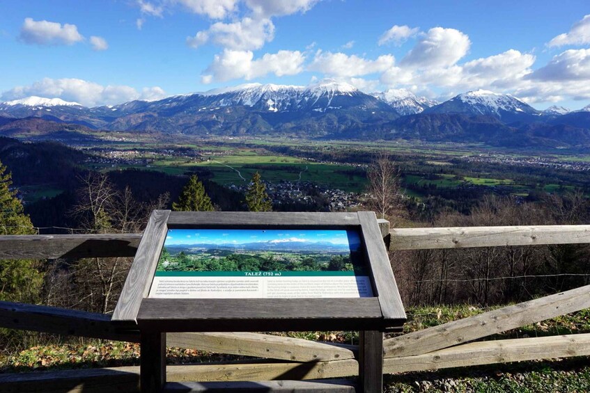 A mountain landscape with a wooden sign displaying information. 3