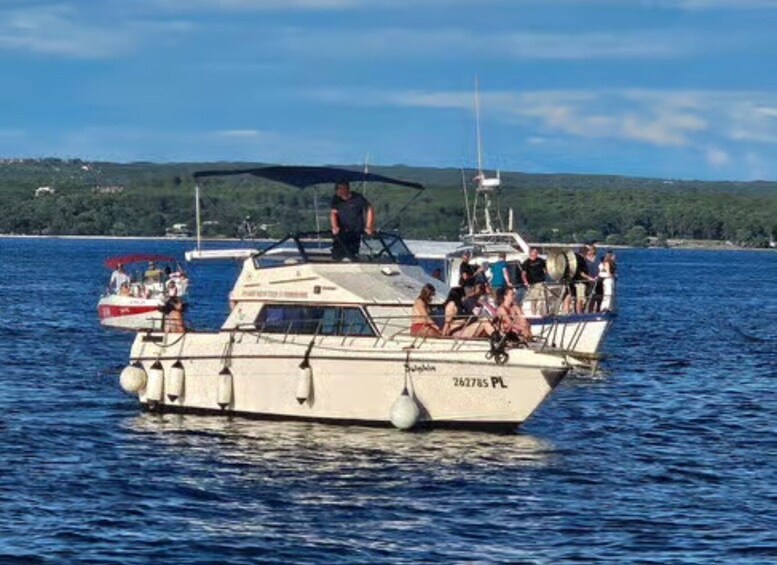 A boat with people on board, a clear sky, and a distant shoreline. 5