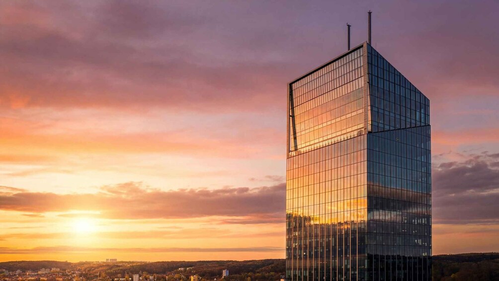 A modern glass skyscraper with a sunset in the background. 4