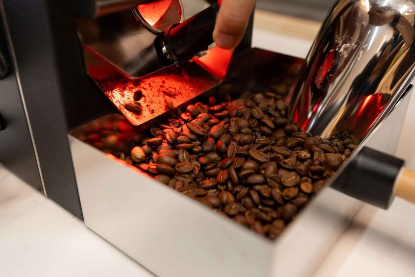 A coffee grinder dispensing coffee beans into a container. 3