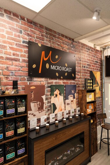 A coffee shop interior with a brick wall, a sign reading 'Micro Roast,' and a display of coffee bags. 2