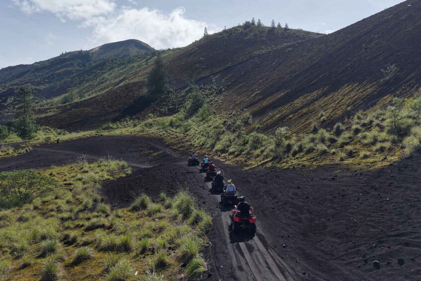 A group of people on all-terrain vehicles descending a steep, rocky hillside. 2
