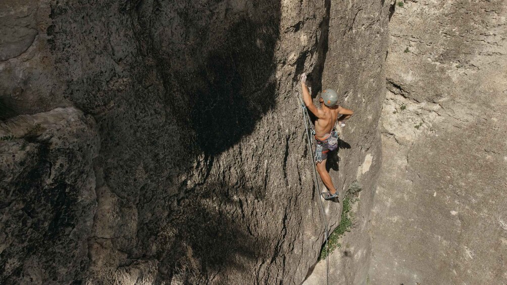A person rock climbing a steep, rocky cliff. 2
