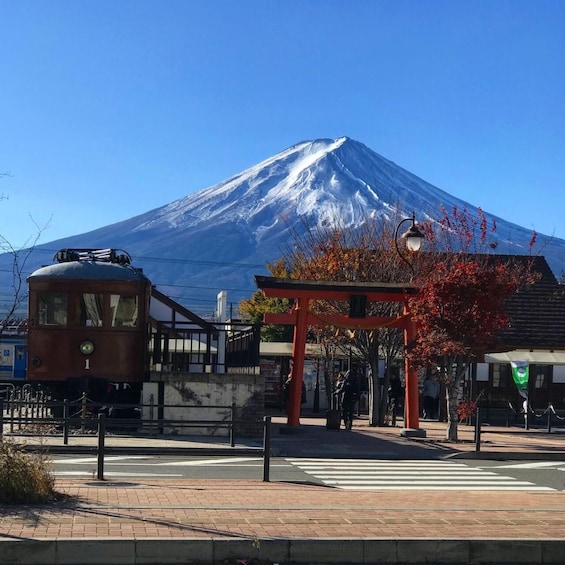 A tram, a red torii gate, and a snow-capped mountain in the background. 1