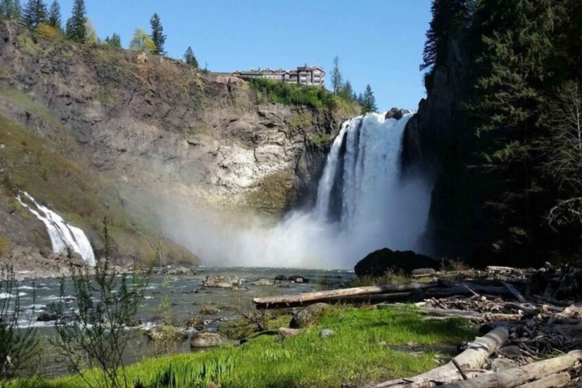 A multi-tiered waterfall, a river, and a lodge on a cliff. 5