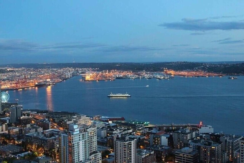 A coastal cityscape at dusk with illuminated buildings, a prominent Ferris wheel, and a large body of water with a ship. 4
