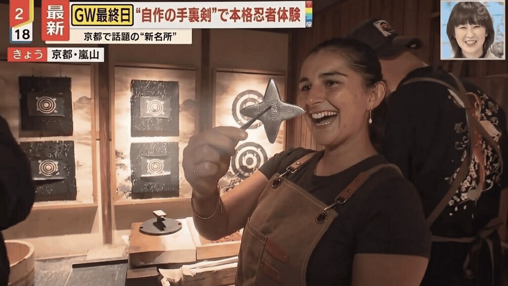 A person holding a star-shaped object, with a display of circular targets in the background. 2