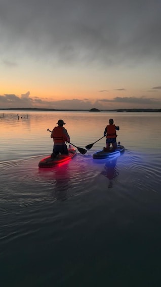 Two paddleboarders on a calm lake at sunset. 5