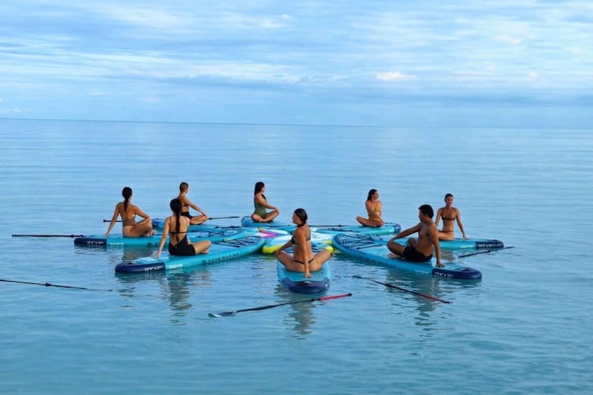People sitting on paddleboards in a calm sea. 4