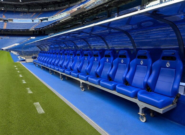 A stadium with blue seats and a green field. 3