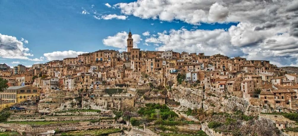 A densely packed hillside town with historic buildings and a prominent minaret. 2