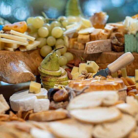 A charcuterie board with various cheeses, fruits, nuts, and a pear. 3