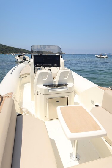 A boat's interior with a steering wheel, a console, and seating. 4