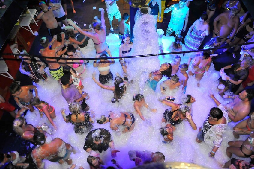 A crowded indoor space with people engaging in a water activity, possibly a party or event. 1
