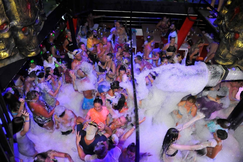 A crowded indoor space with people engaged in a water activity, surrounded by large sculptures. 1