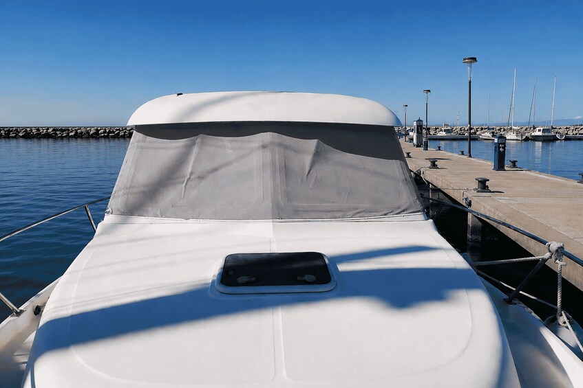 A boat docked at a marina with a clear blue sky and calm water. 3