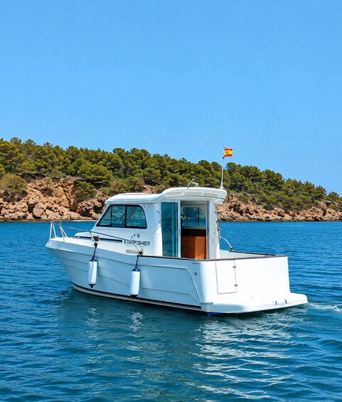 A white boat named 'Starfisher' on calm blue water with a rocky coastline and green trees in the background. 4