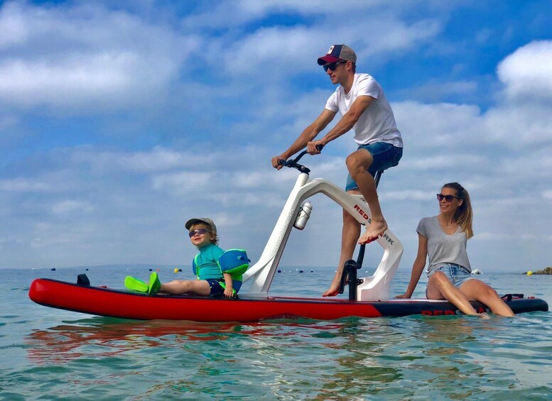 Three people on a paddleboard in the water with a clear sky. 5