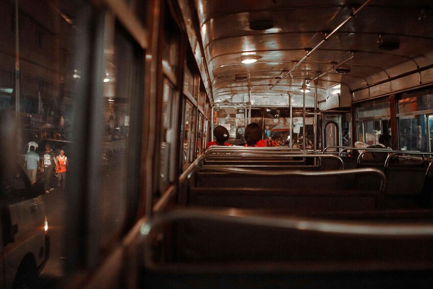 The interior of a bus with rows of seats and overhead compartments. 2