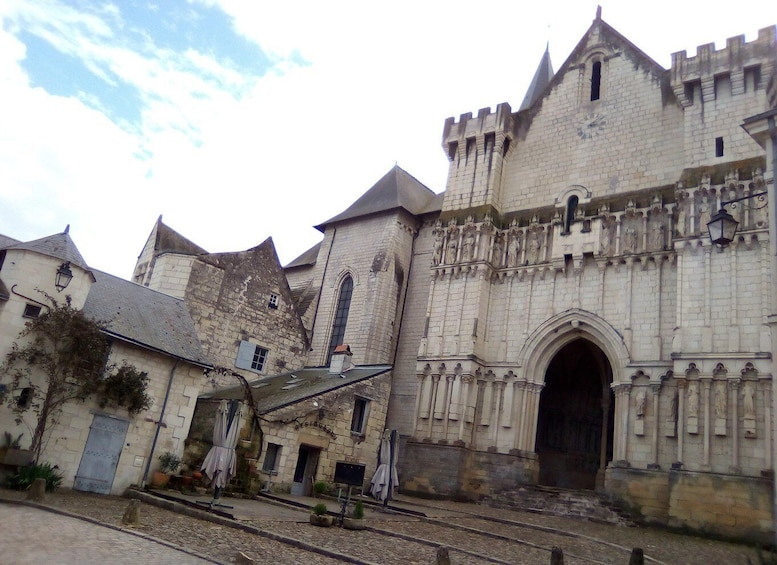 A historic stone building with a large arched entrance and a tower. 1