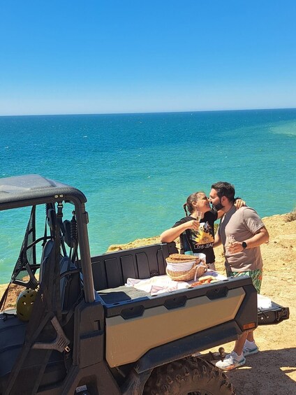 A dune buggy parked on a beach with a clear view of the ocean. 2