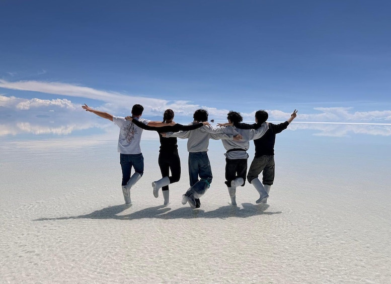 A group of people jumping on a salt flat with a clear sky. 5