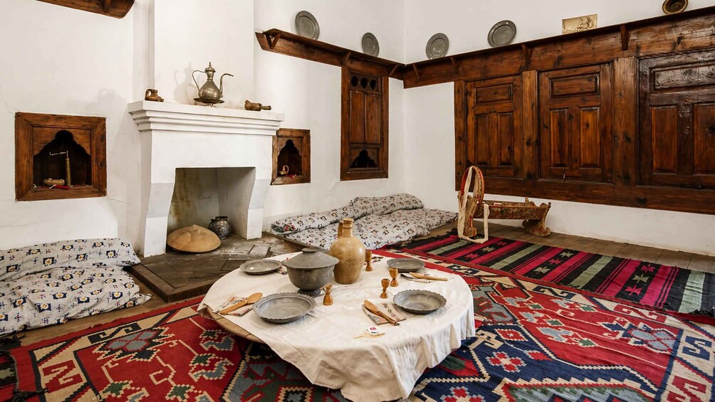 A traditional room with a fireplace, wooden cabinets, and patterned rugs. 2