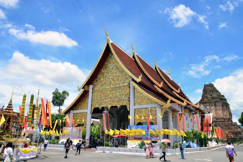 A traditional Thai temple with ornate decorations and a large rock formation in the background. 2