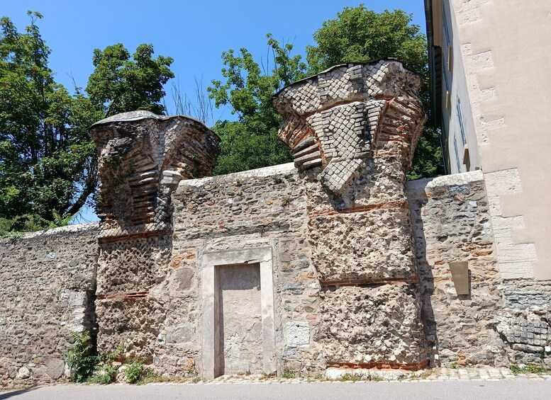 Ancient stone walls with a door and two large stone structures. 5
