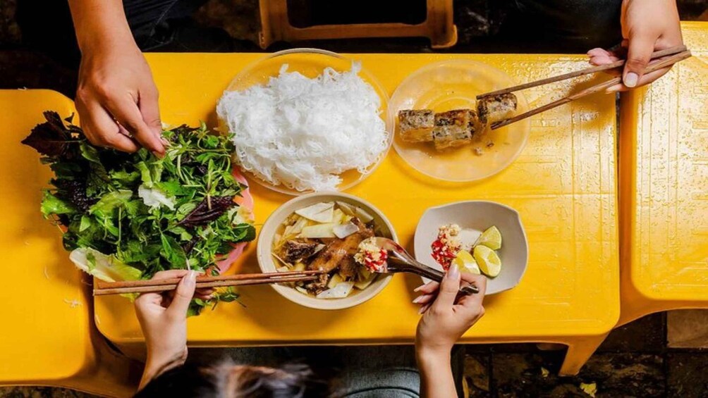 A table with various dishes including rice, grilled meat, and vegetables. 2