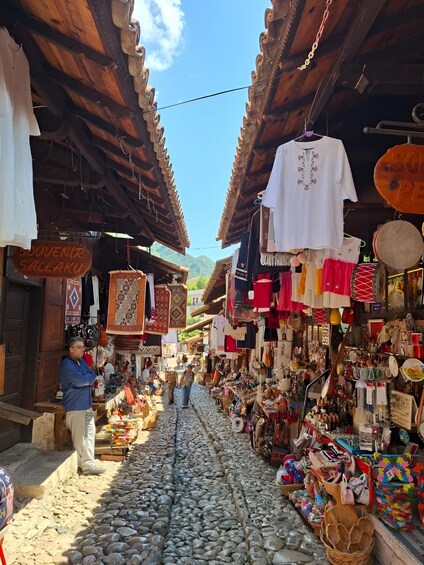 A traditional market with stone-paved ground and wooden structures. 2