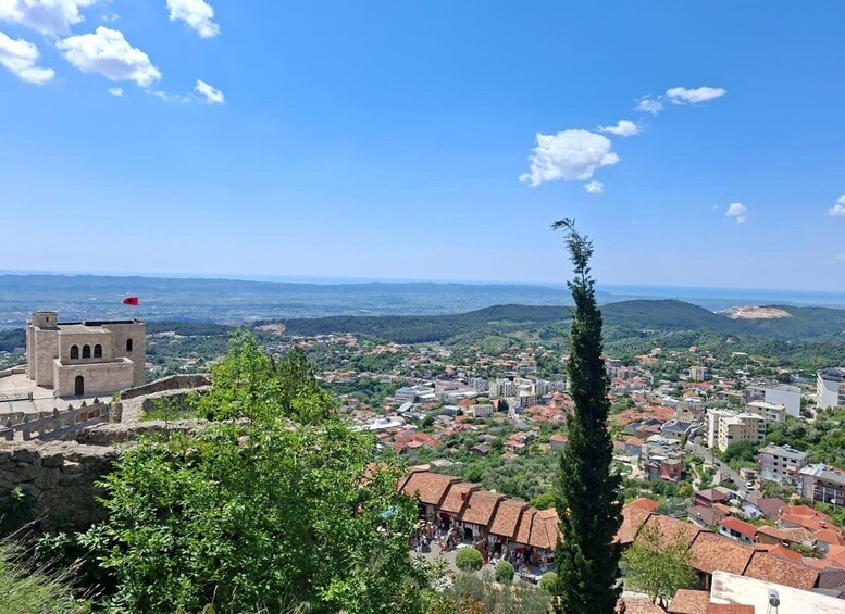 A town with a prominent tower, a clear blue sky, and a view of the surrounding landscape. 1