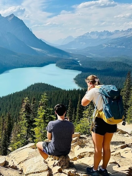 Two people on a mountain overlooking a lake and forest. 5
