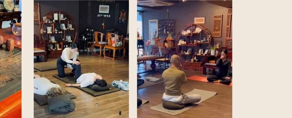 A room with people practicing yoga on mats, wooden furniture, and shelves with various items. 1