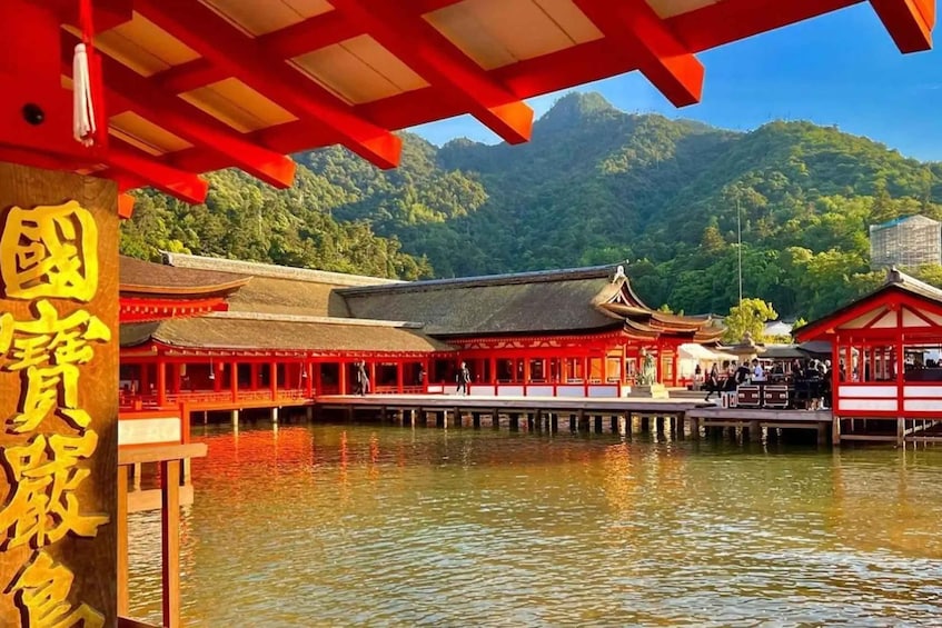 A traditional Chinese pavilion over water, with red buildings and a mountainous backdrop. 4