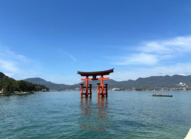 A red torii gate in water with mountains in the background. 1