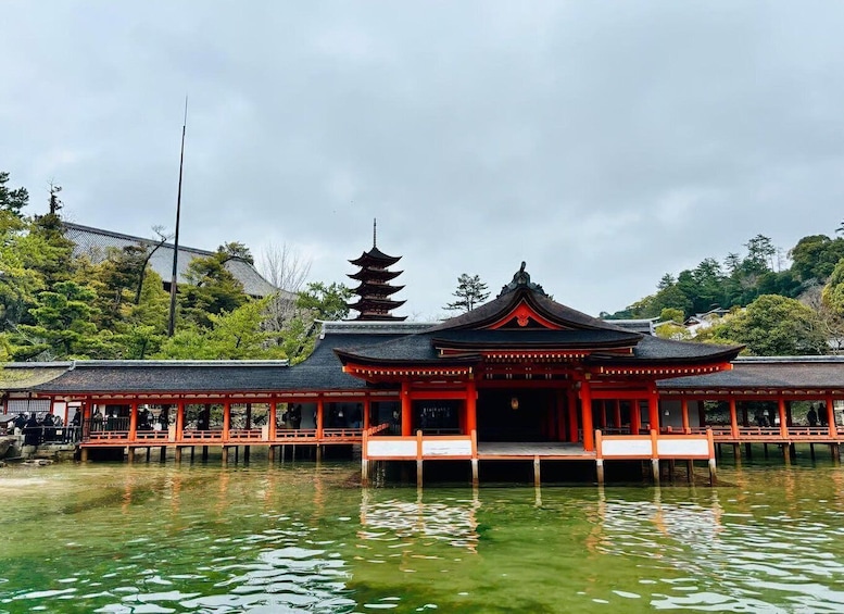 A traditional Japanese temple with a pagoda, surrounded by water and greenery. 2